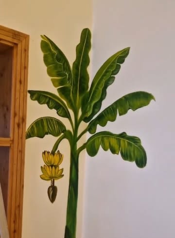 Banana Tree: A full-height banana tree, fruit and all, painted into the corner beside a doorway.